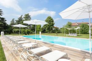 维洛尔巴Residenza Cartiera 243 Country House的一个带白色躺椅和遮阳伞的游泳池