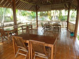 庞岸达兰爪哇泻湖住宿加早餐旅馆的木甲板上设有桌椅的餐厅