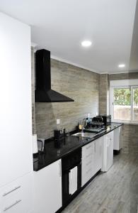 里斯本Belém River Apartment II的厨房配有白色橱柜和黑色台面