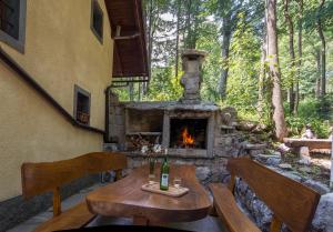 StrmicaHoliday House Vodice na Lazu的庭院设有石制壁炉、桌子和椅子。