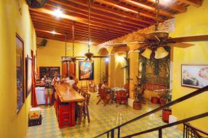 圣玛尔塔La Brisa Loca Hostel的一间餐厅,人们坐在房间里桌子旁
