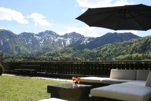 巴德哥依斯恩巨龙酒店的一个带沙发和雨伞的庭院和山脉