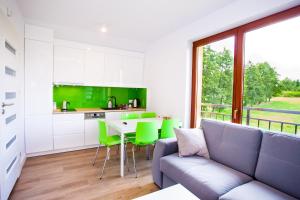 威利兹卡Apartamenty SaltApart2的客厅配有沙发和带绿色椅子的桌子