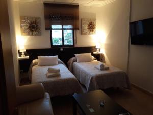 卡拉芭蒂纳Miramar Habitaciones的一间酒店客房,设有两张床和电视