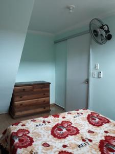 欧纳波利斯Casa de amigos e parentes的一间卧室配有一张床、梳妆台和风扇
