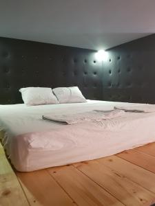 奥西耶克Apartman Lena Loft - best value, best choice!的一间卧室配有一张白色大床和黑色床头板