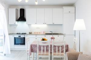 普利格拉迪卡Guest House Simoni的厨房配有白色橱柜和桌椅