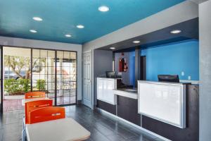 巴顿威洛巴顿威洛北5号州际公路瓦卡班德酒店的厨房配有橙色椅子和蓝色天花板