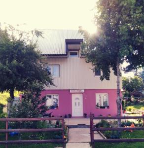 扎布利亚克Apartments Obradović Milan的粉红色的房子,前面有栅栏