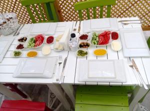 切什梅Alya Mou Butik Hotel的一张白色桌子,上面放着食物板