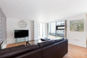 爱丁堡Stylish Garden View Apartment的客厅配有沙发和墙上的时钟