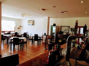 莱佩Hotel Portugal的一间在房间内配有桌椅的餐厅