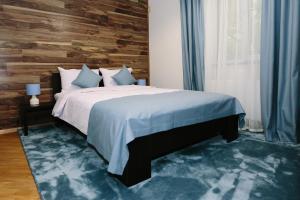 利沃夫Sunny Hotel的一间卧室设有一张床和木墙