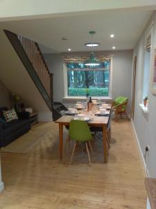爱丁堡Lowood Cottage的一间带桌子和绿色椅子的用餐室