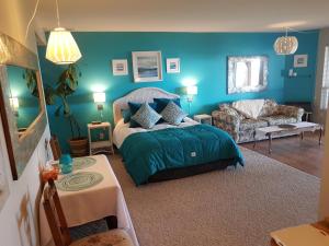 锡谢尔特戴维斯湾住宿加早餐旅馆的蓝色的卧室配有床和沙发