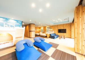 伊豆明治馆碧风日式旅馆的一间带木墙的客厅和一间带蓝色椅子的大房间。