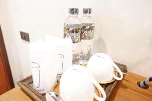 拜县拜县约卡塔酒店的一张桌子,上面有两瓶白花瓶和苏打水