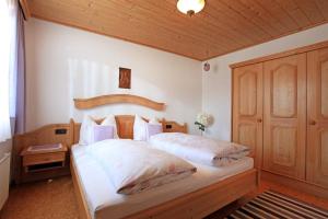 埃尔毛Ferienwohnung Gimplinger的一间卧室配有一张大床和木制床头板