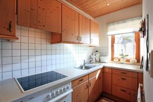 埃尔毛Ferienwohnung Gimplinger的一个带木制橱柜和水槽的厨房
