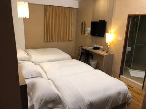 恒春古城河堤时尚旅店的酒店客房设有两张床和电视。