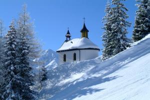卡普尔Apart Oberhaus的一座白雪覆盖的山丘上的教堂