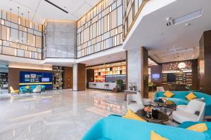 郑州郑州高新希尔顿欢朋酒店的一个带蓝色沙发和椅子的大型大堂