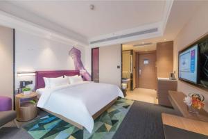 郑州郑州高新希尔顿欢朋酒店的卧室配有一张白色大床和电视。