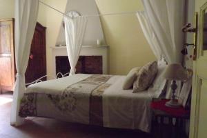 TresanaB&B Il Tempo Del Vento-Camere e Appartamenti的一间卧室配有一张带天蓬的白色床
