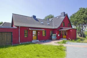 蒂索Ferienhaus Utkiek Soe - Terrasse, Garten, strandnah的一间红色的房子,有黄色的门和院子
