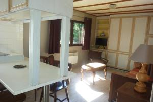 Pertheville-NersRelais Du Saussay的厨房以及带桌椅的起居室。