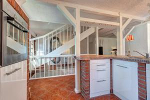 塞巴特阿尔贝克Haus Kieferngrund的一间厨房,配有白色橱柜和楼梯