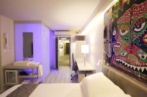 特拉维夫Link Hotel & Hub By Dan Hotels的一间设有一张床的客房,墙上挂着一幅画