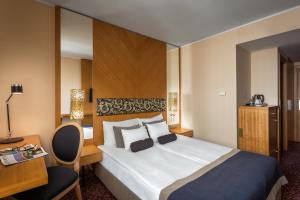 布达佩斯布达佩斯玛拉玛拉酒店的配有一张床和一张书桌的酒店客房