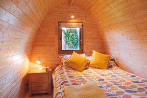 法尔茅斯崔根湖泊山林小屋的小木屋内一间卧室,配有一张床