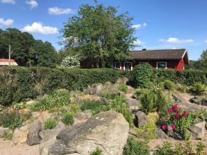 LångåsTuvagård B&B Vindhästar的一座花园,在房子前面有岩石和鲜花