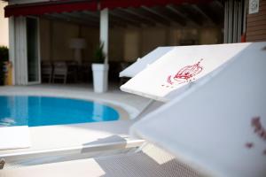 加尔达Hotel Imperial ***S的一张桌子,上面有龙虾标志,旁边是游泳池