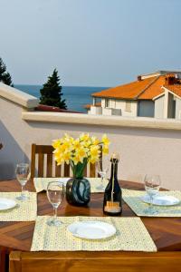 普拉维拉达马客房公寓的一张带黄色鲜花和一瓶葡萄酒的木桌
