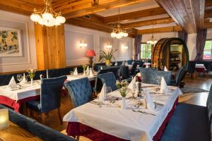泰哈姆山麓弗拉德尼茨泰奇维尔特酒店的用餐室配有桌椅和吊灯。