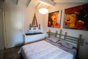 韦尔卡纳La Vedetta的卧室配有一张床,墙上挂有绘画作品