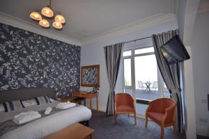 托基巴巴科姆酒店的一间卧室设有一张床、一台电视和一个窗口。