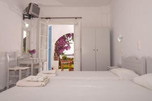 德里奥斯尼克勒塔一室公寓酒店的一间白色卧室,配有两张床和一张书桌