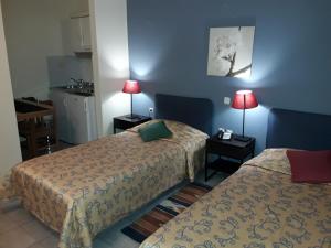 亚历山德鲁波利斯艾缇纳公寓酒店的酒店客房设有两张床和两盏灯。