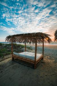 维加伊托维查依托马堪尼酒店的海滩上草伞下的一张床铺