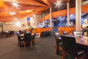 陶波陶波湖区度假酒店的餐厅设有木制天花板和桌椅