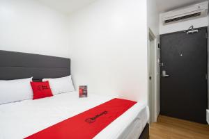 雅加达RedDoorz Plus @ Danau Sunter Utara的一间卧室配有一张床铺,床上铺有红色毯子