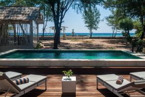 吉利特拉旺安珊瑚花都海滨别墅的一个带椅子的游泳池,享有海景