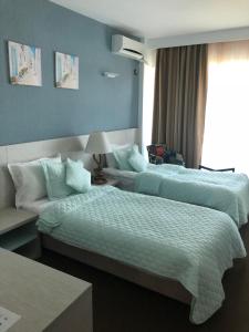 马马亚Alcor Beach Hotel的酒店客房设有两张床和窗户。