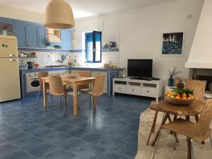 马蒂纳塔Casa Vacanze MARESOLE的厨房配有蓝色橱柜和桌椅