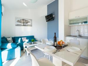奥米沙利Lush Apartment in Omi alj near Seabeach的客厅配有桌子和蓝色沙发