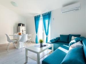 奥米沙利Lush Apartment in Omi alj near Seabeach的客厅配有蓝色的沙发和桌子